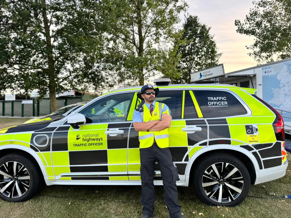 Traffic officer standing beside a marked response vehicle